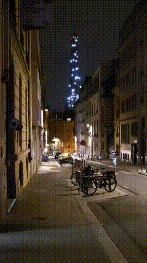 nighttime Eiffel Tower light show at a distance