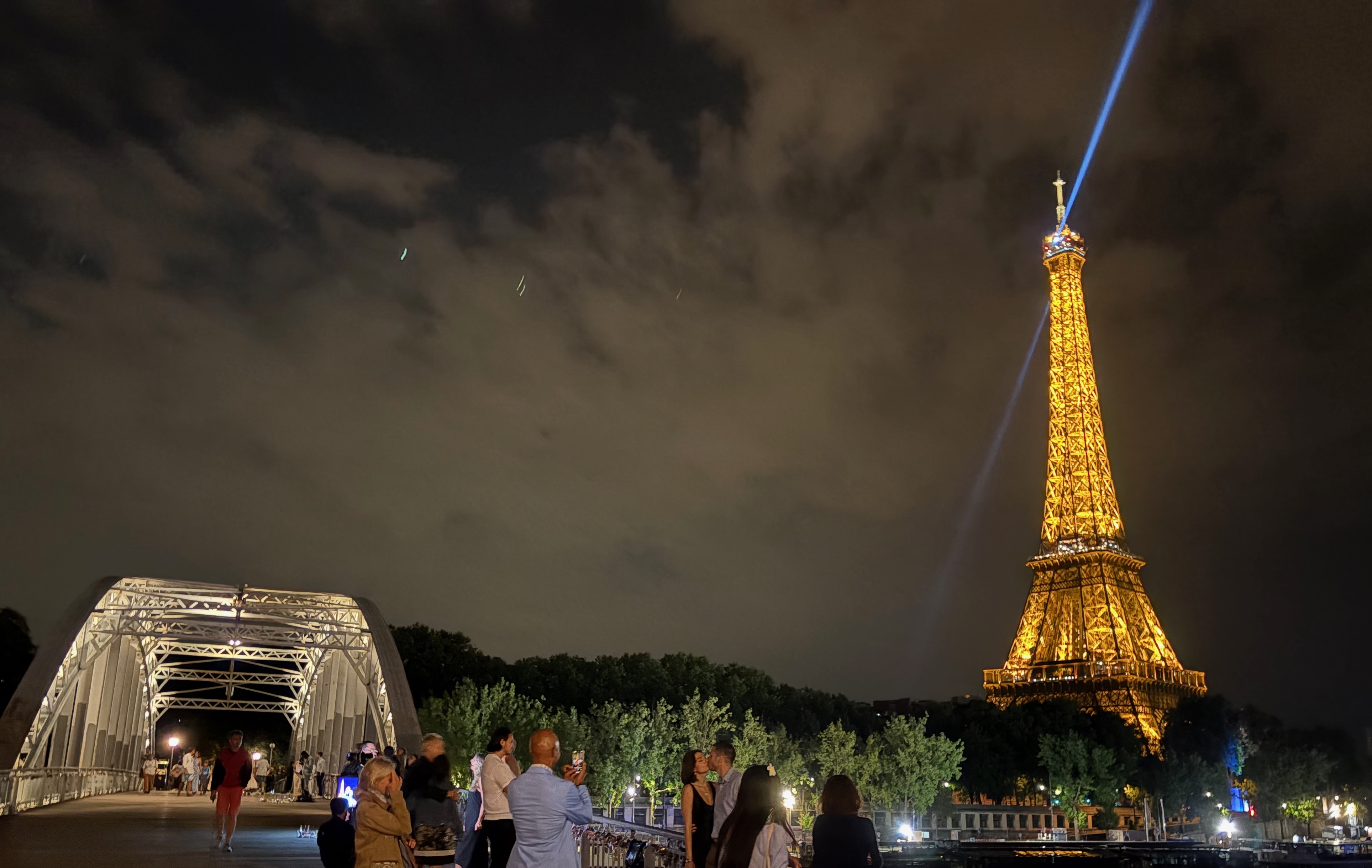 nighttime spotlight on top of the Eiffel Tower