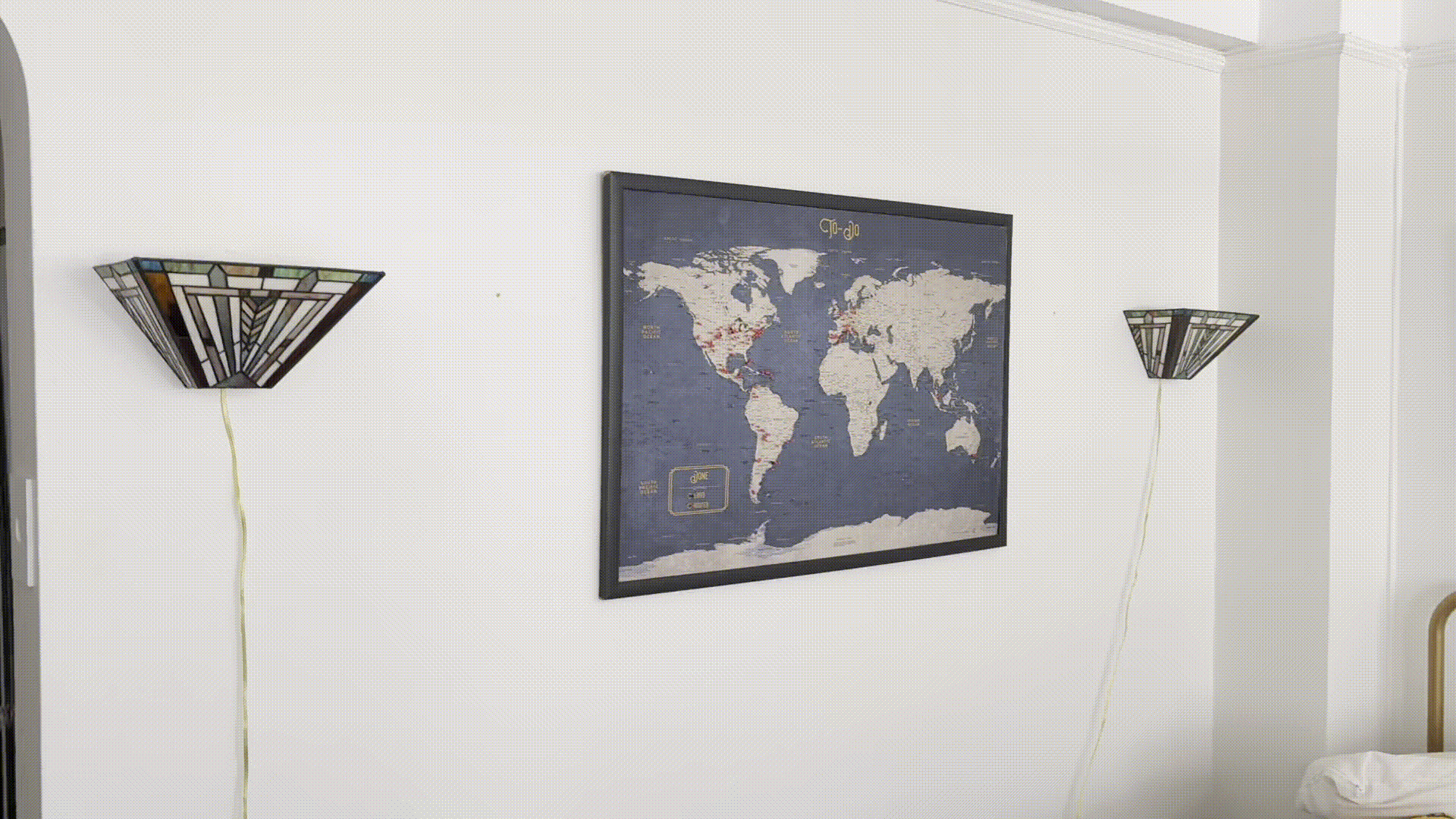 Lamps replaced with art deco-style Tiffany glass sconces, mirror replaced with map of the world